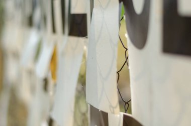 Pankart Rabitz ızgarasına bağlı. Delinmiş rüzgar delikli beyaz pankart. Rüzgar akışına direnci azaltmak için özel delikler.