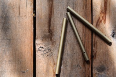 Ahşap zemine karşı üç yeşil alüminyum tüp. Sert, çatlak tahtalar. Doğal ışıklandırma. Yakın plan. Seçici odak.