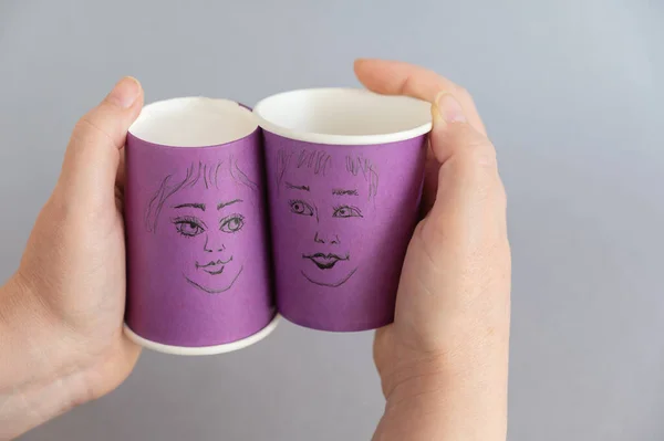Женщина Держит Два Фиолетовых Стакана Нарисованными Лицами Мужские Женские Лица — стоковое фото