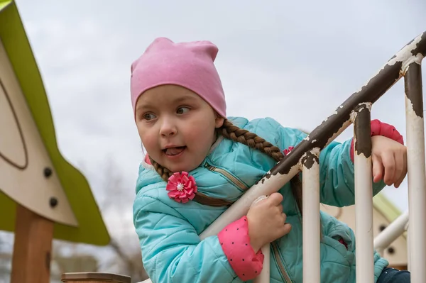Uzun at kuyruklu ilgili bir kızın portresi. Beş yaşında bir çocuk oyun parkında dünya umurunda olmadan oynuyor..
