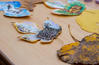 Odanın içindeki bir masanın üzerinde üç hayvan çizimi var. Bir baykuş, bir ayı yavrusu ve bir at ağacın yapraklarına boya çizilir. Resim, çağdaş sanat, boş zaman, eğlence..