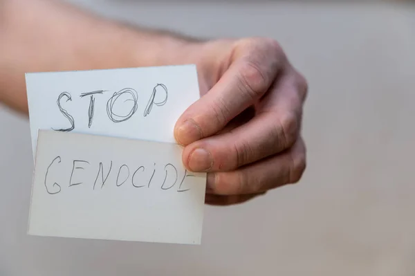 Σταματήστε Γενοκτονία Λέξεις Γραμμένες Οδοντωτά Γράμματα Χέρι Ενός Άνδρα Κρατά — Φωτογραφία Αρχείου