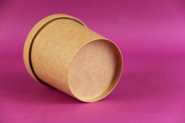 Götürmek için yiyecek. Kapalı silindirik kağıt kapaklı, renkli arka planlı. Kahverengi yiyecek kabı çorba, dondurma, erişte ya da diğer yiyecekler için..