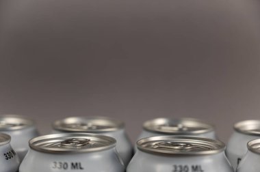 330 ml teneke kutu yakın çekim. Metalik gümüş bireysel içecek kapları. Ön odak noktası. Gürültü, bulanıklık, tahıl etkisi