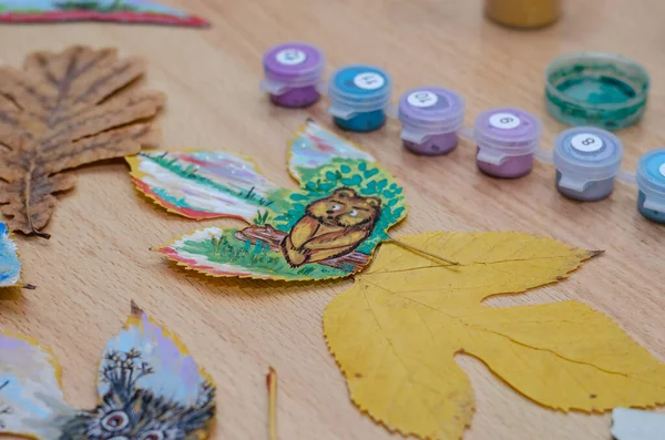 Odanın içindeki bir masanın üzerinde üç hayvan çizimi var. Bir baykuş, bir ayı yavrusu ve bir at ağacın yapraklarına boya çizilir. Resim, çağdaş sanat, boş zaman, eğlence..