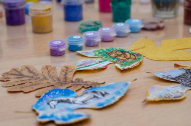 Odanın içindeki bir masanın üzerinde üç hayvan çizimi var. Bir baykuş, bir ayı yavrusu ve bir at ağacın yapraklarına boya çizilir. Resim, çağdaş sanat, boş zaman, eğlence..