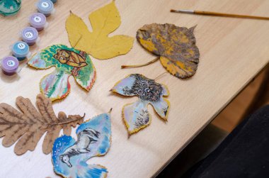 Odanın içindeki bir masanın üzerinde üç hayvan çizimi var. Bir baykuş, bir ayı yavrusu ve bir at ağacın yapraklarına boya çizilir. Resim, çağdaş sanat, boş zaman, eğlence..