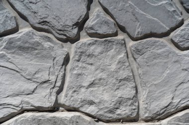 Gri taştan bir duvarın dokusu. Taş yüzeyindeki çatlaklara ve desenlere şekil ver. Soyut çoklu görev arkaplanı
