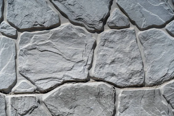 Gri taştan bir duvarın dokusu. Taş yüzeyindeki çatlaklara ve desenlere şekil ver. Soyut çoklu görev arkaplanı