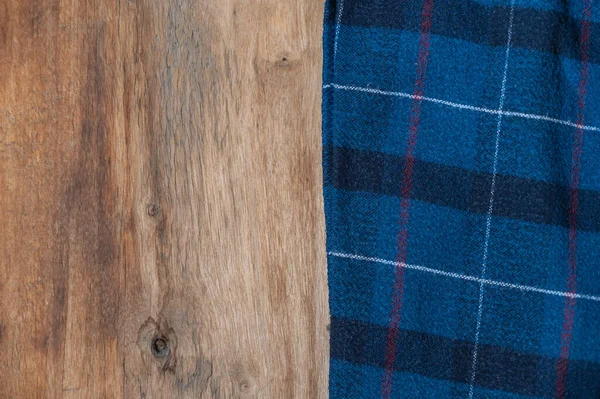 蓝色的格子织物衬托在木制的背景上 餐巾粗糙的木板或厨房桌子上的毛巾或厨房餐巾 — 图库照片