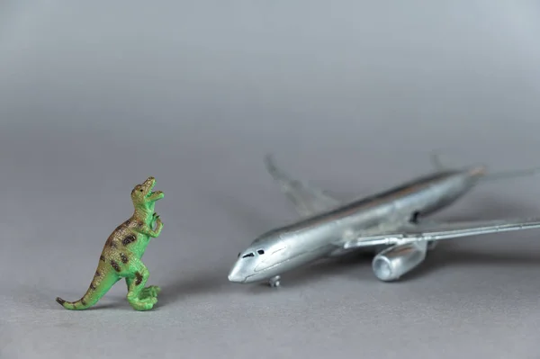 Dětské Hračky Stříbrné Letadlo Dinosauří Miniatura Šedém Pozadí Malá Zelená — Stock fotografie