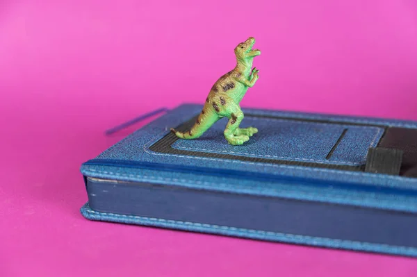 Dinosaurus Uzavřený Modrý Deník Purpurovém Pozadí Zelená Plastová Miniatura Dravého — Stock fotografie