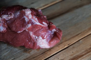 Ahşap arka planda çiğ domuz eti. Koca kaslı bir domuz omzu eski çatlak tahtaların üzerinde duruyor. Seçici Odaklanma