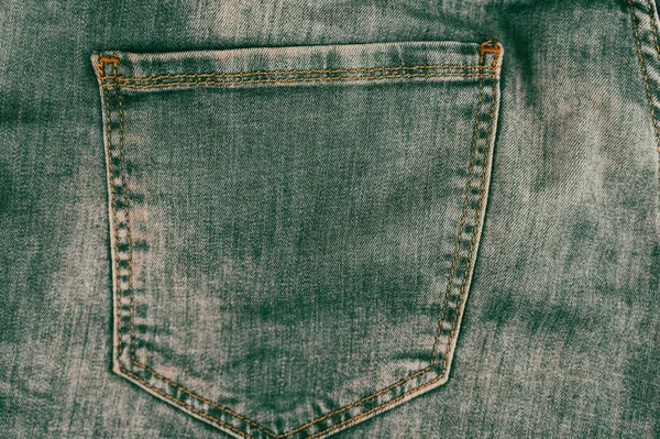后兜里的灰色绿色牛仔裤 牛仔质地 粗糙的粗布 橙色线缝针 随便穿 现代趋势 具有文本和设计元素复制空间的多任务背景 — 图库照片