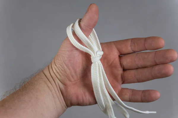 Мужчина Белым Шнурком Руке Серый Фон Плоский Шнурок Висящий Большом — стоковое фото