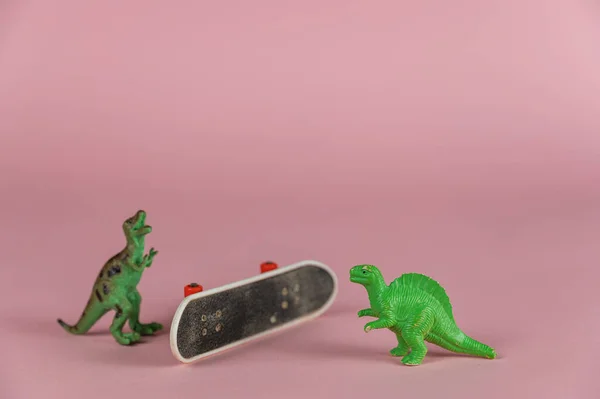 Duas Miniaturas Dinossauros Mini Skate Cabeça Para Baixo Contra Fundo — Fotografia de Stock
