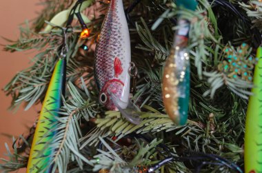 Balık yemi ile süslenmiş bir Noel ağacının yakın çekimi. Plastik yalpalayıcılar. Balık tutmaya. Ukrayna, Kyiv - 01 31 2022