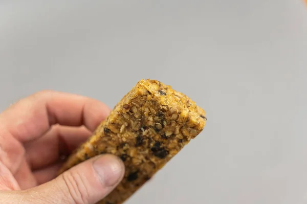 一个男人在棕色手上拿着蛋白质能量棒 一种无麸质 无糖的小吃 燕麦片加水果 健康食品 — 图库照片