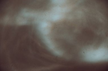 Kahverengi bir duvarda çeşitli soyut şekillerdeki güneş ışınları. Alçılı bir duvarda farklı çizgiler ve ışık noktaları. Farklı tasarım görevleri için soyut çoklu görev geçmişi. Seçici odak.