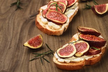 İncirli buğday ekmeği tostu ve ahşap zemin üzerinde ricotta peyniri, yakın görüş, seçici odaklanma. Sağlıklı yemek.