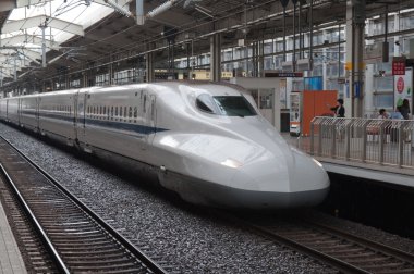 Shinkansen train departs from rail station. clipart