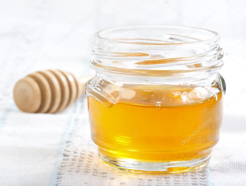 Jar of honey on a white tablecloth