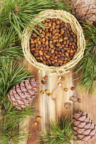 Pine nuts and cones on a wooden table — Stock Photo, Image