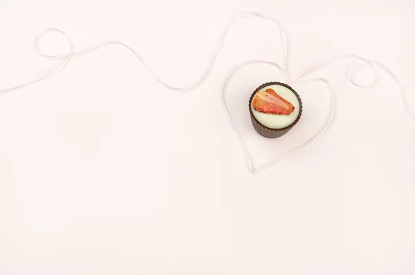 Pastel de chocolate con cinta en forma de corazón en el fondo rosa —  Fotos de Stock
