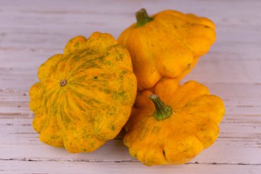 Beyaz arka planda üç turuncu misk kabağı..