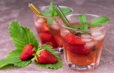 Gri arka planda naneli çilek ferahlatıcı içecek. Yakın plan..