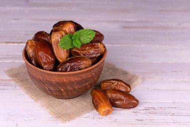 Beyaz ahşap arka planda bir kasede tarihler.