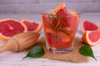 Beyaz bir arka plan üzerine bir bardak greyfurt suyu.