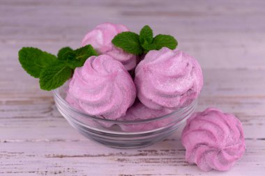 Beyaz arkaplanda bir tabakta pembe şekerlemeler..