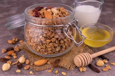 Bir kavanoz süt ve bal içinde granola. Sağlıklı kahvaltı kavramı.