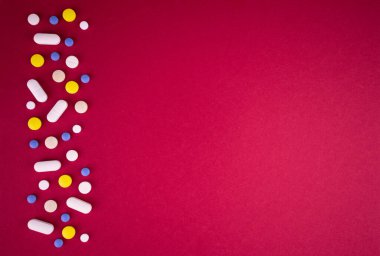 Kırmızı arka plandaki hapların tıbbi geçmişi. Boşluğu kopyala.