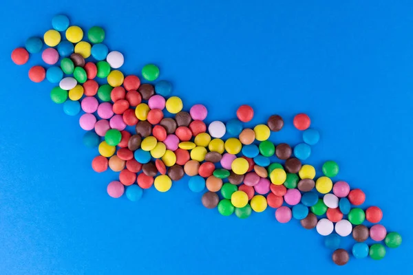 Veelkleurige Snoepjes Een Felblauwe Achtergrond Bovenaanzicht — Stockfoto