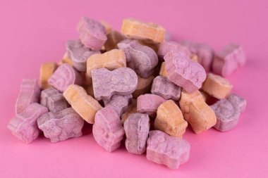 Pembe arka plandaki hayvan formunda çocuklar için vitaminler. Yakın plan..