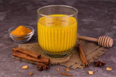 Bir bardak zerdeçal latte. Tarçın ve baharatlı altın süt. Sağlıklı vejetaryen içeceği..