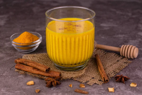 Bir bardak zerdeçal latte. Tarçın ve baharatlı altın süt. Sağlıklı vejetaryen içeceği..