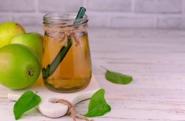 Beyaz arka planda bir kavanozda elma suyu. Boşluğu kopyala..