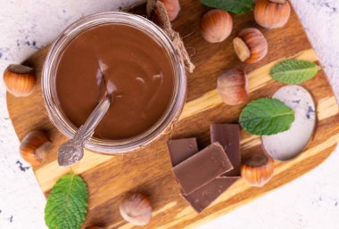  Çikolata ezmesi ya da bambu tahtasındaki cam kavanozda fındıklı fındık kreması. Düz yatıyordu.