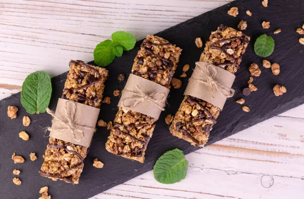 Siyah tahtada üç tane granola çubuğu. Düz yatıyordu.