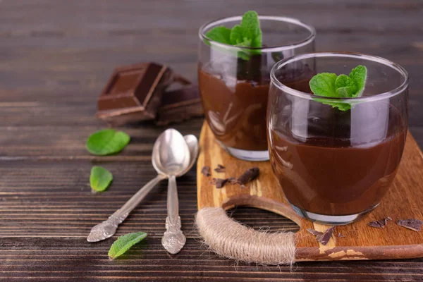 Chocolate pudding in glasses on a wooden background.Copy space.