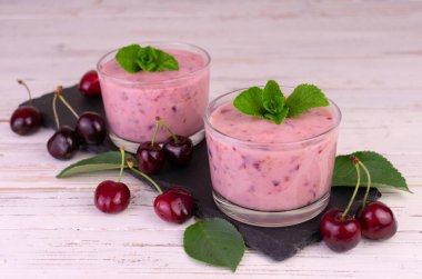 Siyah tahtada düşük bardakta vişneli muzlu smoothie..