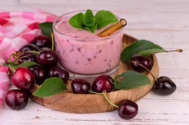 Tahta tepside bardakta taze vişneli smoothie..