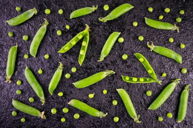 Siyah bir arka planda taze bezelyeler..