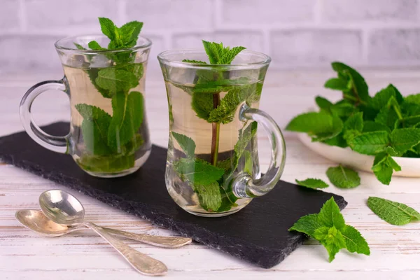 Mint tea. Soothing tea with fresh mint on a rustic white background.