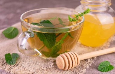 Şeffaf fincanda ballı nane çayı. Yakın plan..