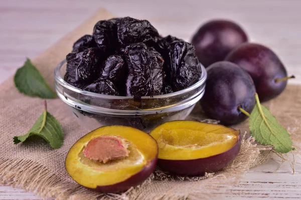 Dried plums or prunes and fresh plums in a bowl.Close-up.