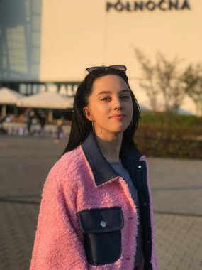 Pembe ceketli genç bayan, Polonya, Varşova 'daki ticaret merkezinin yanındaki altın saat sokakta vuruldu..